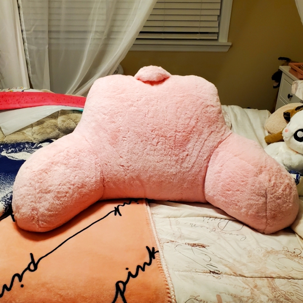 Pink faux fur reading pillow.
